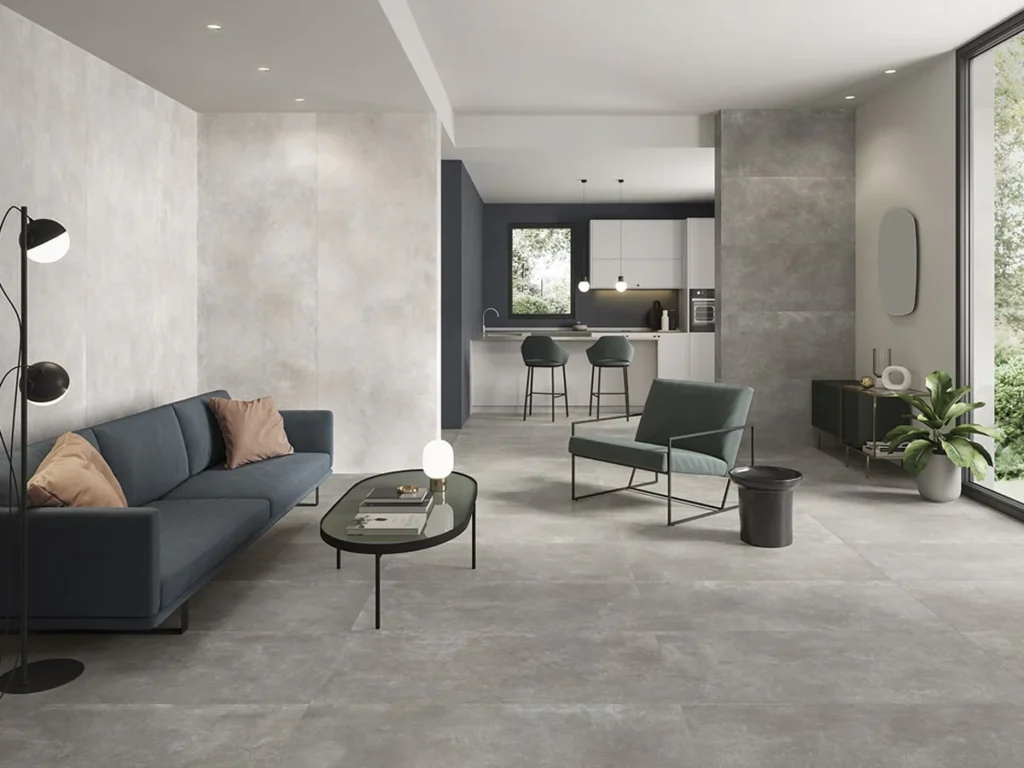 Salon ouvert avec cuisine et carreaux gris effet béton Saime Icon au sol et au mur