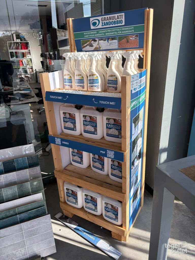 De EasiHold-display van Granulati Zandobbio met spuitflessen, bussen van 5 liter en proefbakjes in de winkel van Tegeloutlet