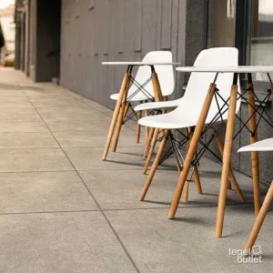 Sfeerbeeld: terras van een koffiebar met witte stoelen op lichte beigegrijze tegels